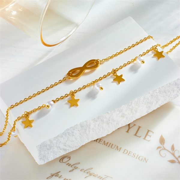 Un bijoux bracelet de cheville en acier inoxydable perle bohème avec des étoiles et un verre d'eau.