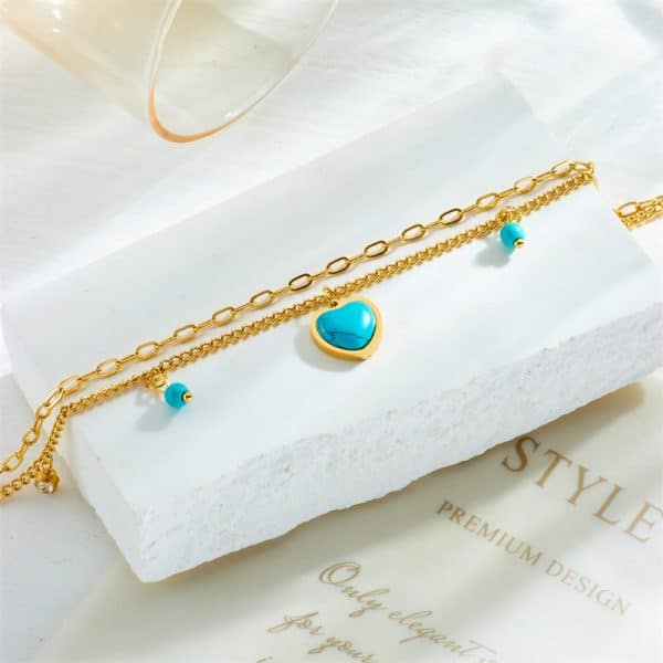 Un bijoux bracelet de cheville pendentif Bleu turquoise avec une breloque en forme de coeur.
