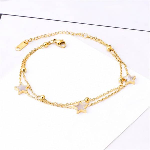 Un Bracelet de Cheville Étoile en Acier Inoxydable avec une forme d'étoile dorée et des perles blanches.