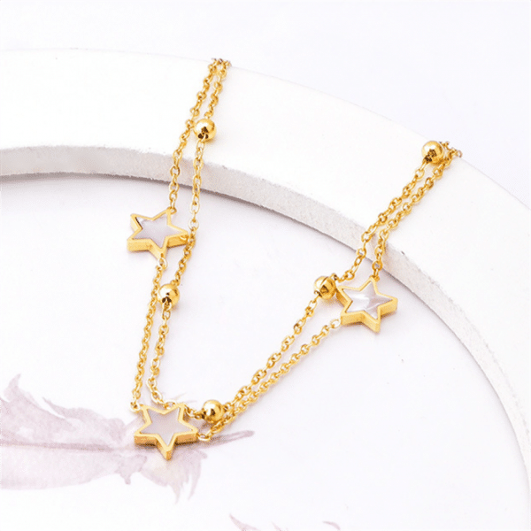 Un bracelet de cheville étoile en forme d'étoile dorée en acier inoxydable avec une étoile bijoux blanche au milieu.