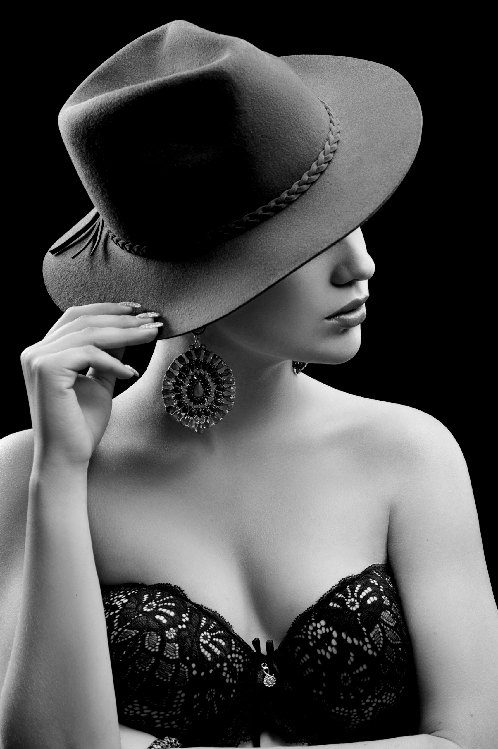 Une photo en noir et blanc d'une femme portant un chapeau avec des bijoux.