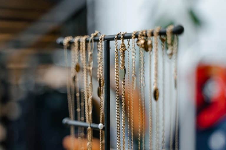 Une exposition de colliers de bijoux accrochés sur un support.