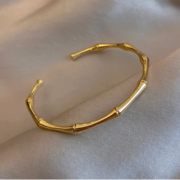 Un bracelet en bambou plaqué or sur fond blanc.