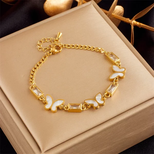 Un bracelet papillon plaqué or sur une boîte.