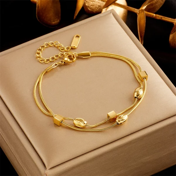 Une paire de bracelets plaqués or sur une boîte.