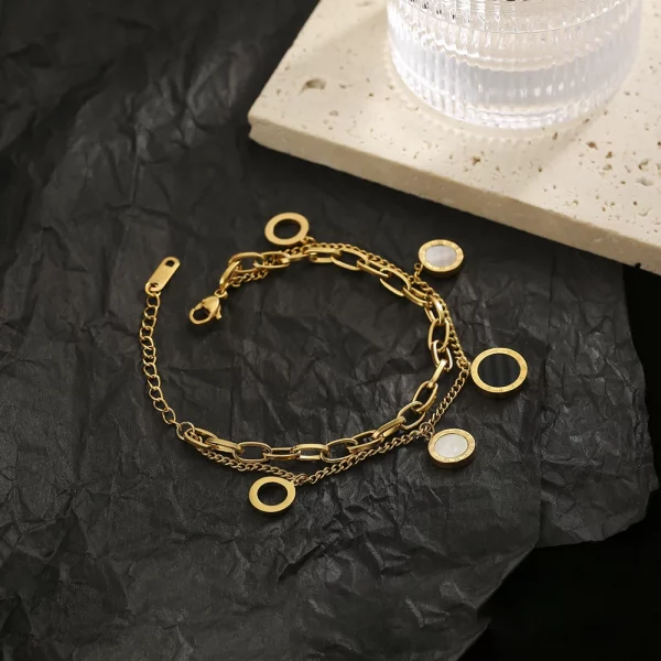 Un bracelet en or avec deux cercles et un verre sur le dessus.