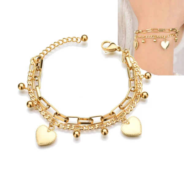 Un bracelet en or avec deux cœurs et une breloque cœur.