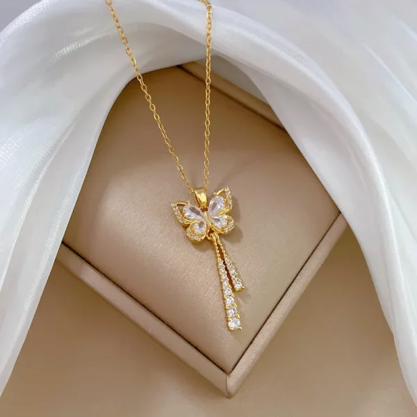 Un collier papillon diamant en acier doré avec un pendentif.