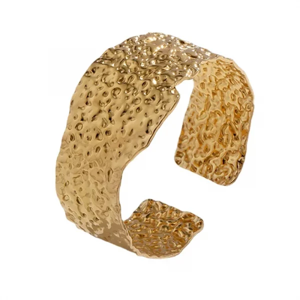 Un bracelet manchette plaqué or avec un motif texturé.