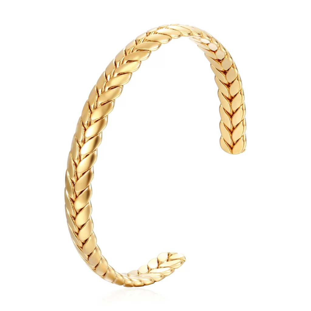 Un bracelet manchette plaqué or avec un motif tressé.