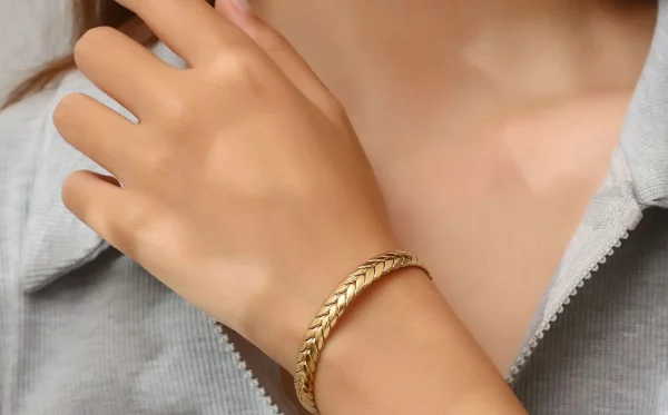 Une femme portant un Bracelet jonc en acier inoxydable Style blé doré et un jonc jonc.