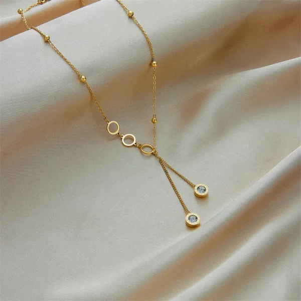 Un collier en acier inoxydable double pendentif romain avec un pendentif de deux diamants.