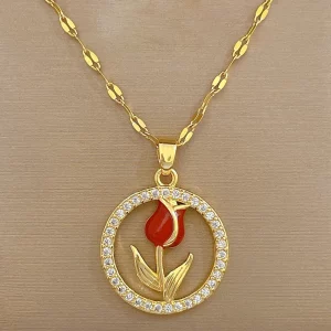 Un collier en or avec une fleur rouge dessus.