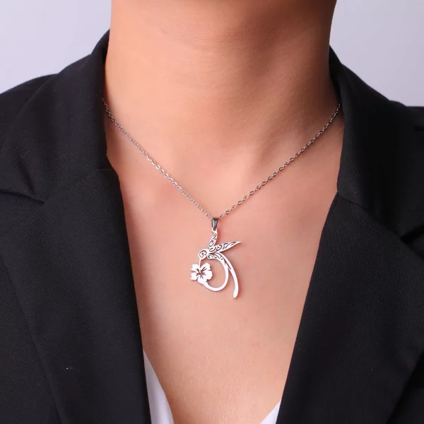 Une femme faisant preuve d'élégance dans son collier colibri élégance, composé d'un collier en argent orné d'un pendentif en forme de cœur.