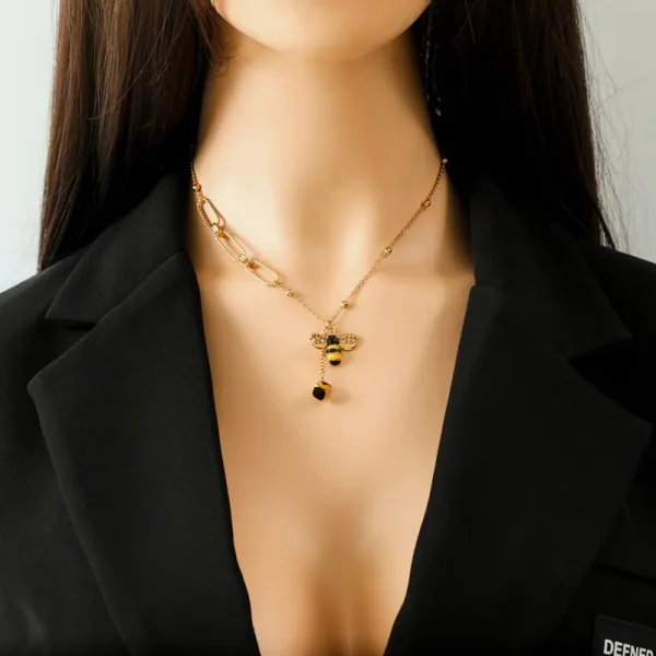 Un mannequin portant un Collier pendentif Abeille en Acier Inoxydable Doré avec un pendentif abeille dessus.