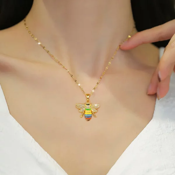 Une femme portant un collier abeille coloré en acier inoxydable.