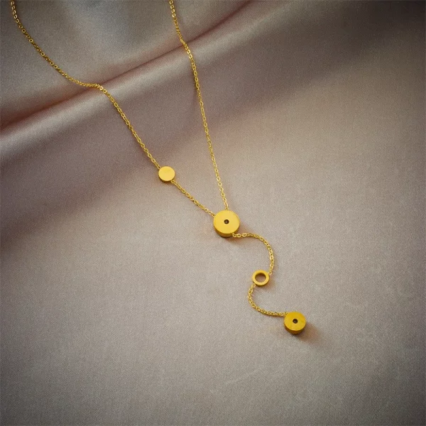 Un Collier acier inoxydable femme doré médaillon avec deux petits cercles dessus.