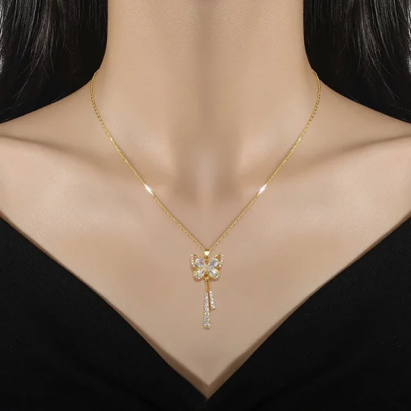 Une femme portant un collier papillon diamant en acier doré.