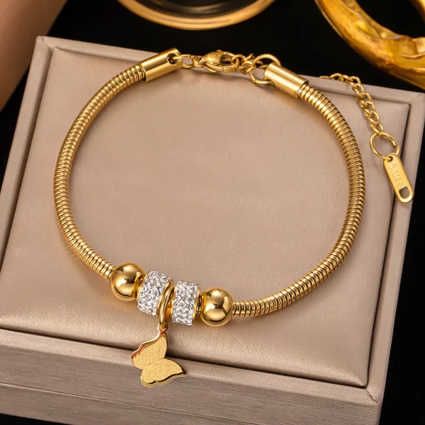 Un bracelet chaîne en acier inoxydable avec un pendentif papillon.