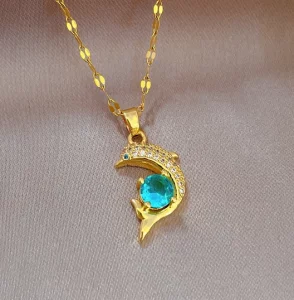 Un collier en or avec un pendentif dauphin émeraude et turquoise.
