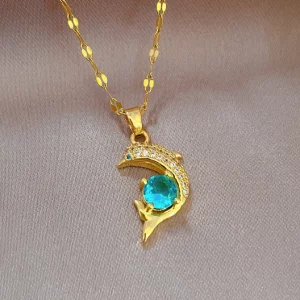 Un collier en or avec un pendentif dauphin émeraude et turquoise.