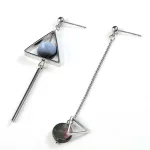 Une paire de boucles d'oreilles asymétrique avec un triangle et une pierre.