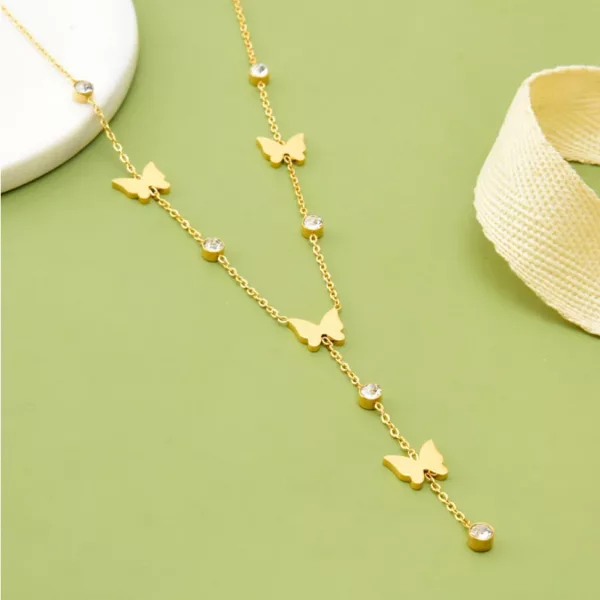 Un collier papillon et perle en acier avec des pendentifs papillon et des perles en acier.
