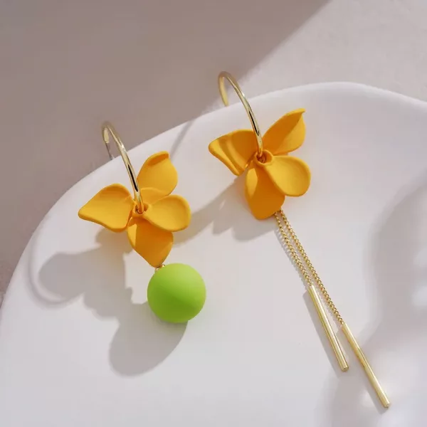 Deux boucles d'oreilles à fleurs jaunes sur une assiette.