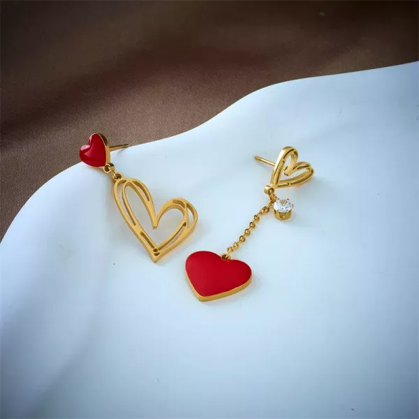 Une paire de boucles d'oreilles asymétriques cœur amour en forme de cœur rouge et doré.
