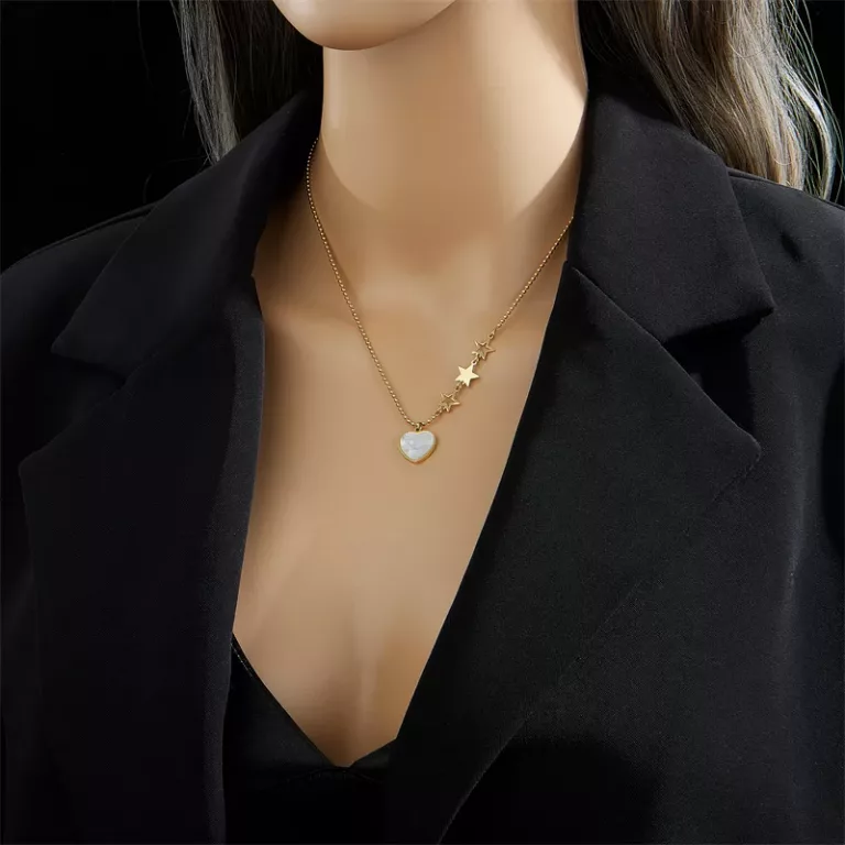 Un mannequin portant un Collier pendentif Cœur Blanc Chaîne Dorée.