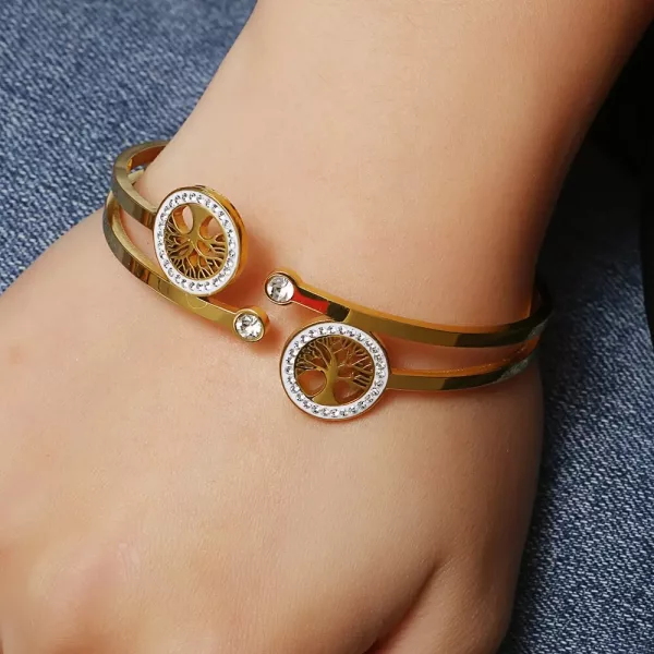 Une femme portant un bracelet Jonc Arbre de Vie Double Doré en or et diamants.