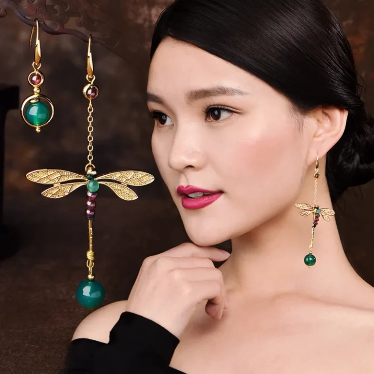une femme qui porte LYRA Boucles asymétriques libellule dorée agate verte