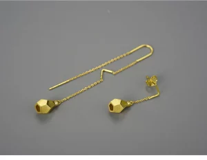 ROSY Boucles d'oreilles asymétriques doré goute sur un fond gris