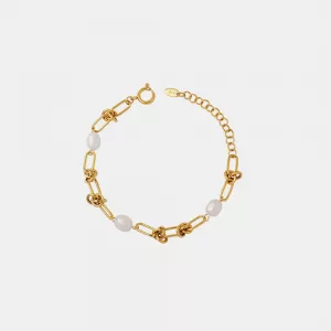Bracelet en chaîne d'or avec des maillons entrelacés, des accents de perles et un fermoir ajustable sur un fond blanc uni.