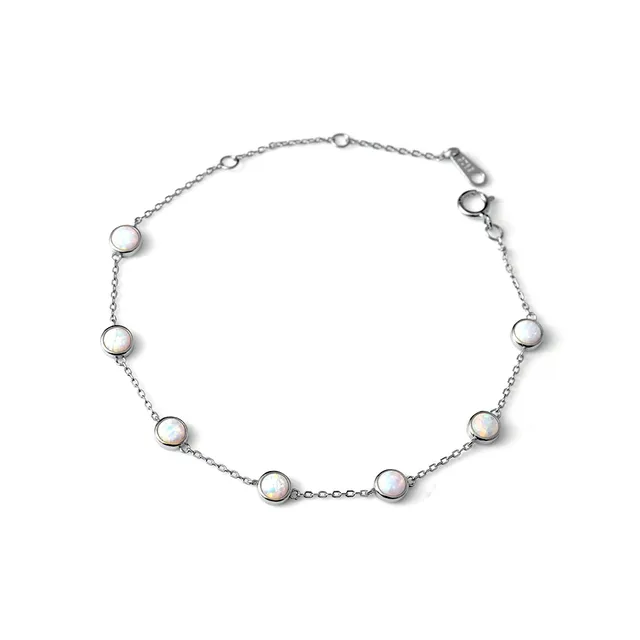 Délicat bracelet en chaîne d'argent orné de sept opales rondes régulièrement espacées et serties dans des biseaux.