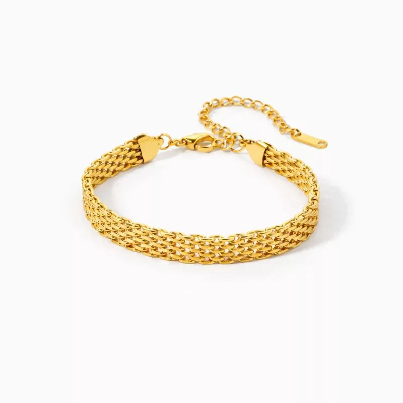 MAÉ Bracelet large en acier inoxydable doré à maille gourmette, avec chaîne d'extension réglable et fermoir mousqueton, présenté sur fond blanc.