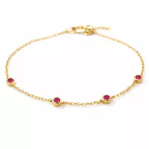 Le Bracelet chaîne dorée perlé avec pierres rouges - Ava présente cinq petites pierres rouges régulièrement espacées sur une délicate chaîne en or, sur fond blanc.