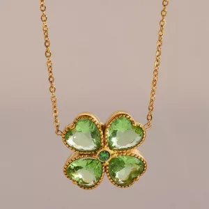 Collier en or orné d'un pendentif en forme de trèfle à quatre feuilles, comportant quatre pierres précieuses vertes en forme de cœur et une petite pierre verte ronde au centre.