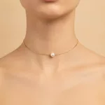 Collier ras de cou porté avec perle sur chaîne dorée