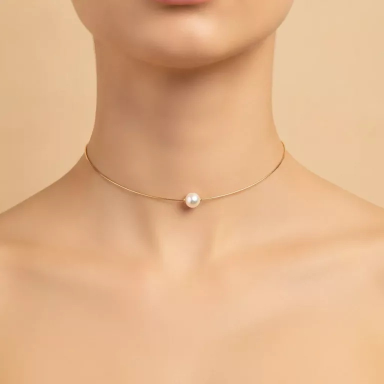 Collier ras de cou porté avec perle sur chaîne dorée