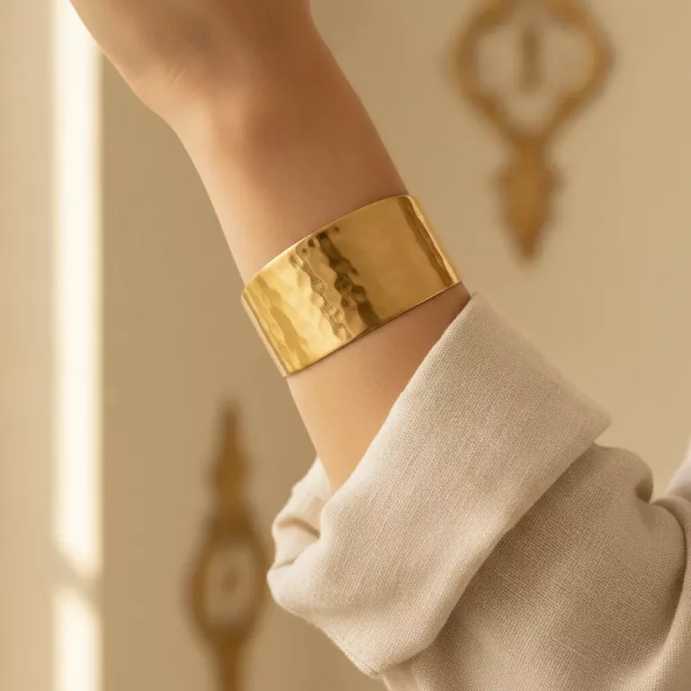 Bracelet manchette dorée martelée portée au poignet
