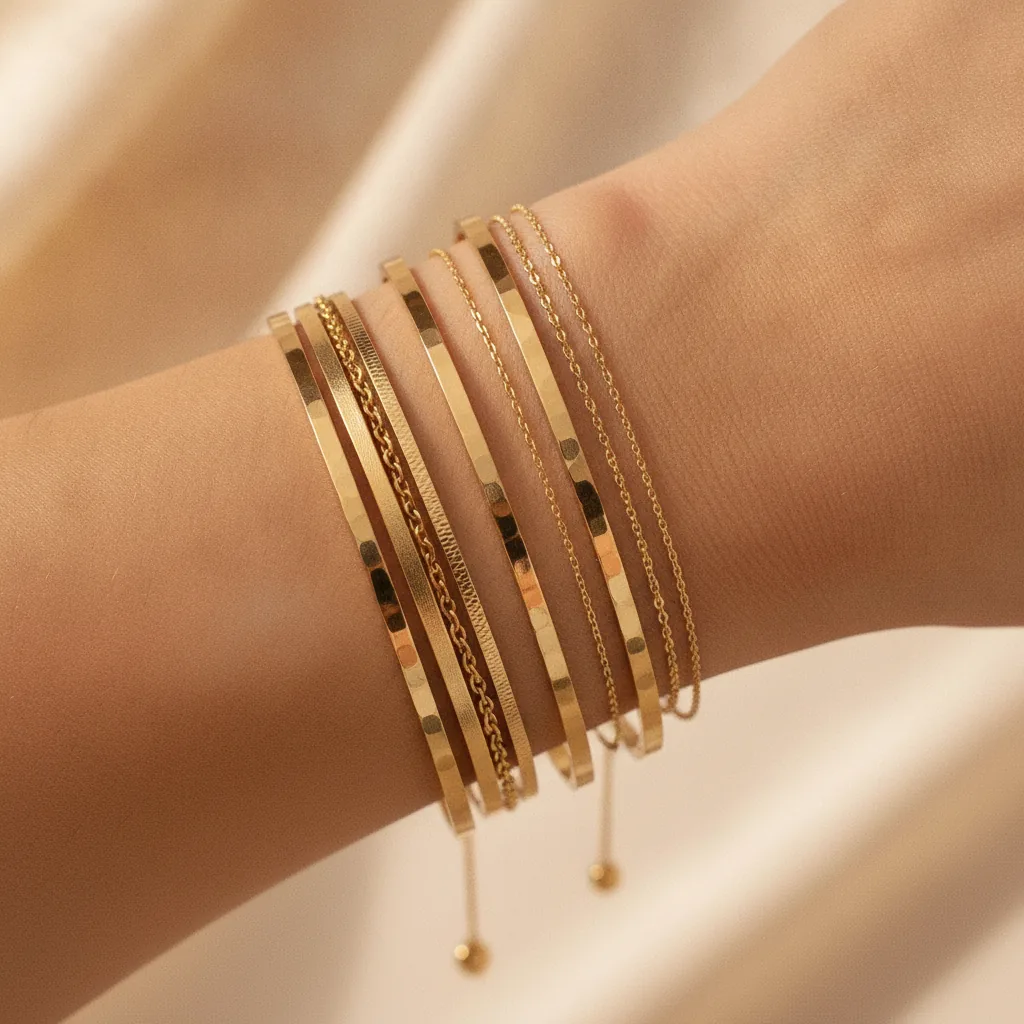 Superposition de bracelets fins dorés au poignet